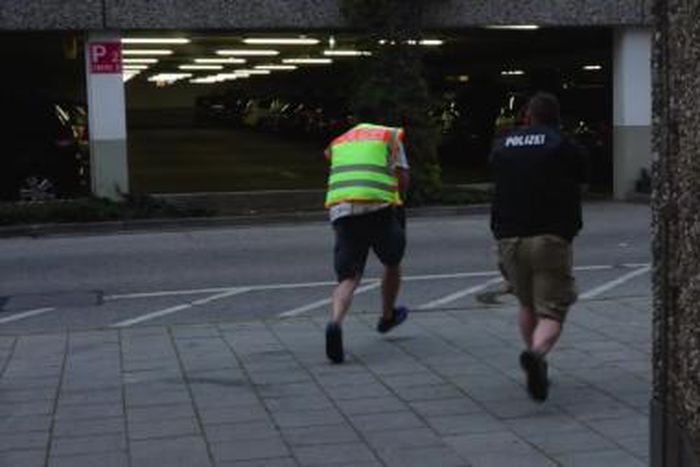 A screen grab taken from video footage shows plain clothes police officers running towards car park of the Olympia shopping mall during shooting rampage in Munich, Germany July 22, 2016.