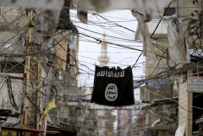 An Islamic State flag hangs amid electric wires over a street in Ain al-Hilweh Palestinian refugee camp, near the port-city of Sidon, southern Lebanon January 19, 2016.