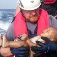 A German rescuer from the humanitarian organisation Sea-Watch holds a drowned migrant baby, off the Libyan cost May 27, 2016.