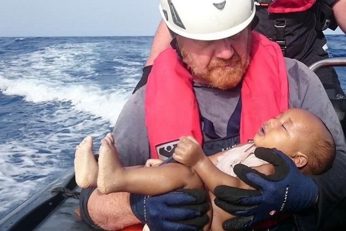 A German rescuer from the humanitarian organisation Sea-Watch holds a drowned migrant baby, off the Libyan cost May 27, 2016.