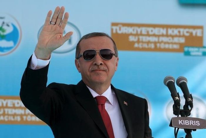 Turkish President Tayyip Erdogan waves to supporters during an inauguration ceremony of a water pipeline project linking Turkey to northern Cyprus, in Myrtoy October 17, 2015. REUTERS/Yiannis Kourtoglou