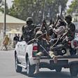 Soldiers and people carrying machetes ride on the back of a vehicle along a street in Gombe , Nigeria, January 30, 2015.