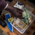A shopkeeper puts money in her cash box at her shop in Hillcrest west of Durban, South Africa, January 11, 2016.