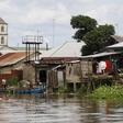 A church minaret is seen behind houses built near the banks of the Nun River on the outskirts of the Bayelsa state capital, Yenagoa, in Nigeria's delta region October 8, 2015.