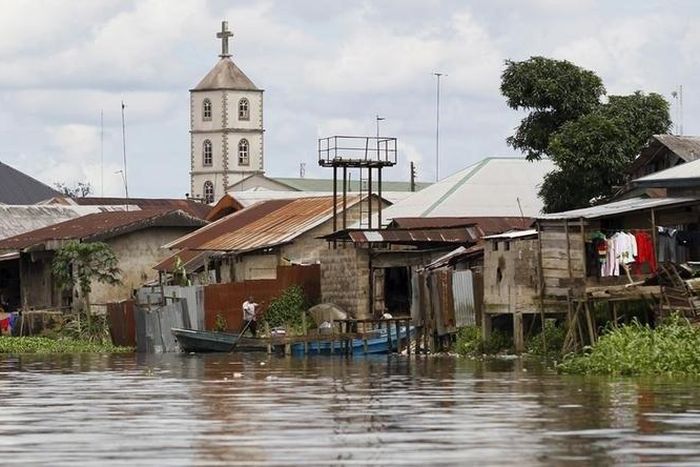 A church minaret is seen behind houses built near the banks of the Nun River on the outskirts of the Bayelsa state capital, Yenagoa, in Nigeria's delta region October 8, 2015.