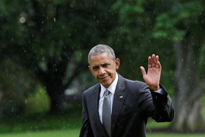 U.S. President Barack Obama waves as he walks under a rain on the South Lawn of the White House upon his return to Washington, U.S., after visiting wounded service members the Walter Reed National Military Medical Center, June 21, 2016. REUTERS/Yuri Gr...