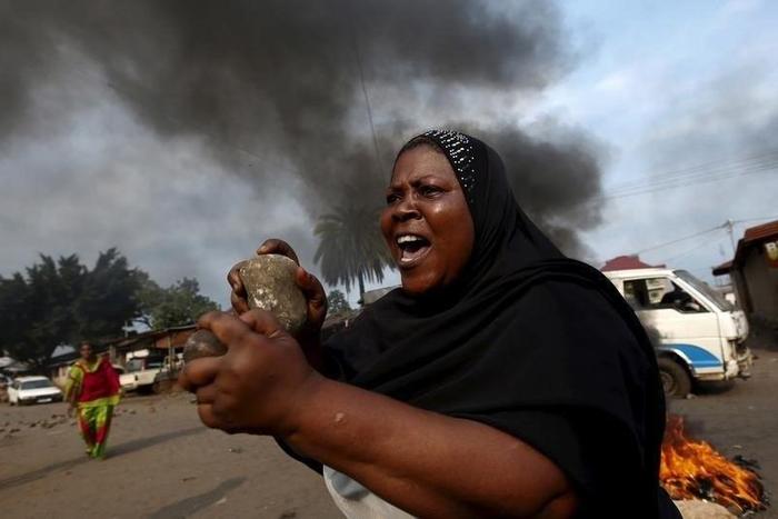 A woman gestures with stones during a protest against President Pierre Nkurunziza and his bid for a third term in Bujumbura May 26, 2015. REUTERS/Goran Tomasevic