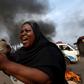 A woman gestures with stones during a protest against President Pierre Nkurunziza and his bid for a third term in Bujumbura May 26, 2015. REUTERS/Goran Tomasevic
