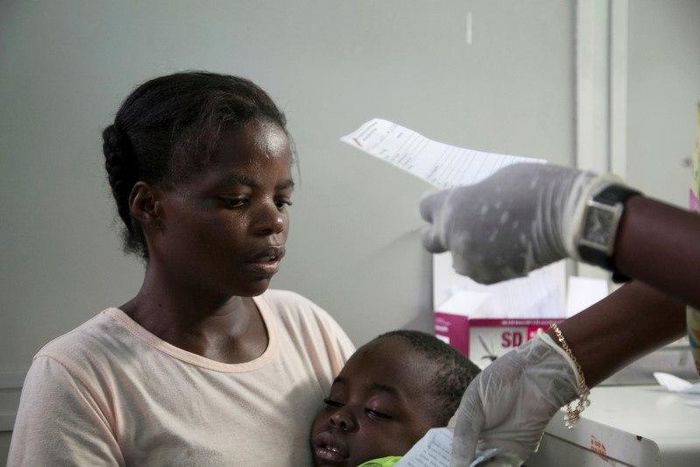 A mother holds her son suffering from yellow fever as she waits for a prescription at a hospital in Luanda?, Angola, March 15, 2016.