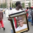A man holds a framed portrait of Nigeria's President Muhammadu Buhari outside the venue of Buhari's inauguration in Abuja May 29, 2015. REUTERS/Akintunde Akinleye