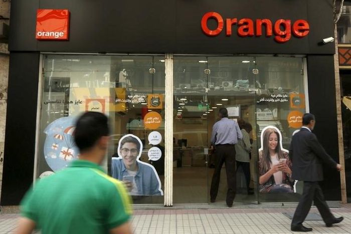 People walk past a new shop of French telecom operator Orange, which was previously known as Mobinil, in Cairo, Egypt, April 6, 2016. REUTERS/Amr Abdallah Dalsh