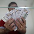 Bank staff shows U.S. hundred dollars bills at AYA Bank's money changer in Yangon July 17, 2015.   REUTERS/Soe Zeya Tun