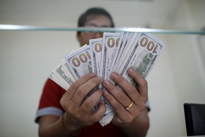 Bank staff shows U.S. hundred dollars bills at AYA Bank's money changer in Yangon July 17, 2015.   REUTERS/Soe Zeya Tun
