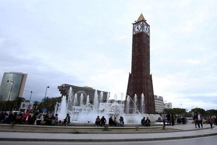 People sit in front of the clock tower at the end of Avenue Habib Bourguiba in Tunis, Tunisia, February 13, 2016.