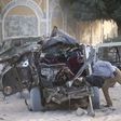 A Somali police officer looks inside the wreckage of a car destroyed when Islamist militants opened fire on government officials in a car and then a car bomb exploded, according to police and a spokesman for Mogadishu's mayor, in Yaqshiid district of S...