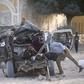 A Somali police officer looks inside the wreckage of a car destroyed when Islamist militants opened fire on government officials in a car and then a car bomb exploded, according to police and a spokesman for Mogadishu's mayor, in Yaqshiid district of S...