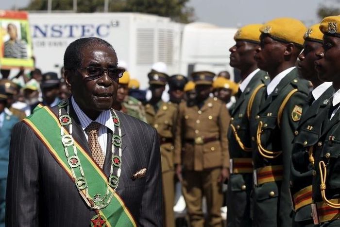 President Robert Mugabe walks past soldiers as he arrives for Zimbabwe's Heroes Day commemorations in Harare, August 10, 2015. REUTERS/Philimon Bulawayo
