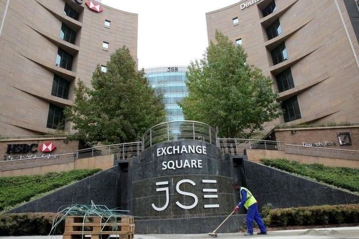 A worker sweeps in front of the Johannesburg Stock Exchange (JSE), in this picture taken March 23, 2016. Picture taken March 23, 2016.
