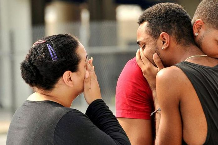 Mourners comfort themselves following Orlando shooting which left 50 people dead.