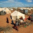 Refugees stand outside their tent at the Ifo Extension refugee camp in Dadaab, near the Kenya-Somalia border in Garissa County, Kenya October 19, 2011.