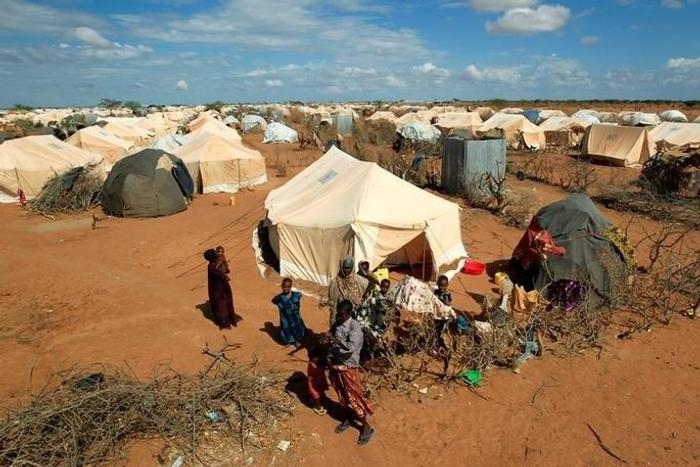 Refugees stand outside their tent at the Ifo Extension refugee camp in Dadaab, near the Kenya-Somalia border in Garissa County, Kenya October 19, 2011.