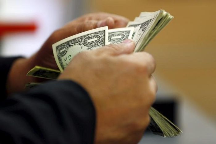 A customer counts his U.S. dollar notes in a bank in Cairo, Egypt March 10, 2016. REUTERS/Amr Abdallah Dalsh