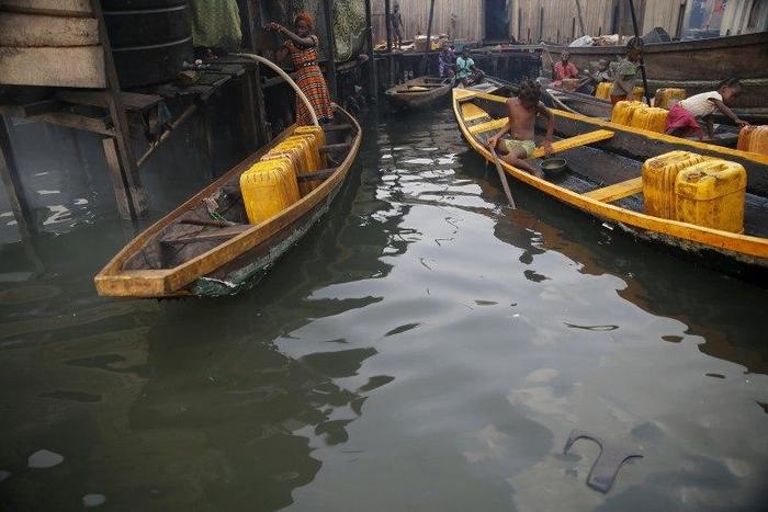 People fetch water in containers in canoes at a water selling point in the Makoko fishing community on the Lagos Lagoon, Nigeria February 29, 2016.
