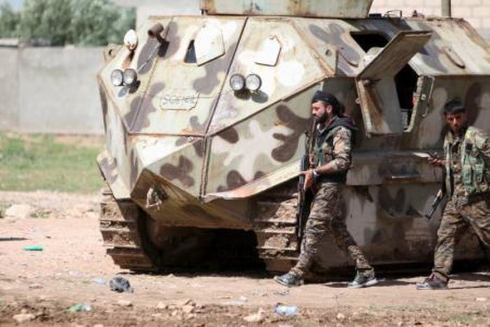 Fighters of the People"s Protection Units (YPG) walk with their weapons in the city of Qamishli, Syria April 21, 2016.