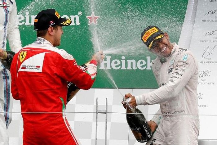 Mercedes F1 driver Lewis Hamilton (R) of Britain and Ferrari F1 driver Sebastian Vettel of Germany celebrate after the race.