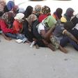 Illegal migrants sit at temporary detention centre after they were detained by Libyan authorities in Tripoli, Libya October 12, 2015. REUTERS/Ismail Zitouny
