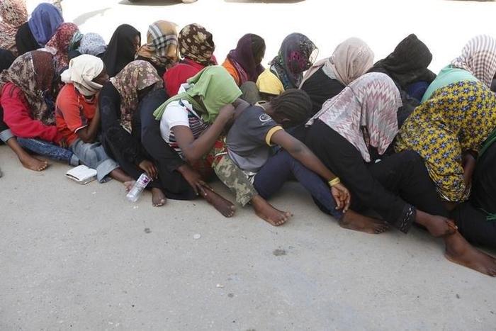 Illegal migrants sit at temporary detention centre after they were detained by Libyan authorities in Tripoli, Libya October 12, 2015. REUTERS/Ismail Zitouny