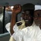 Former Chad President Hissene Habre (R) raises his fist in the air as he leaves a court in Dakar escorted by a Senegalese policeman November 25, 2005,  file photo.   REUTERS/Aliou Mbaye