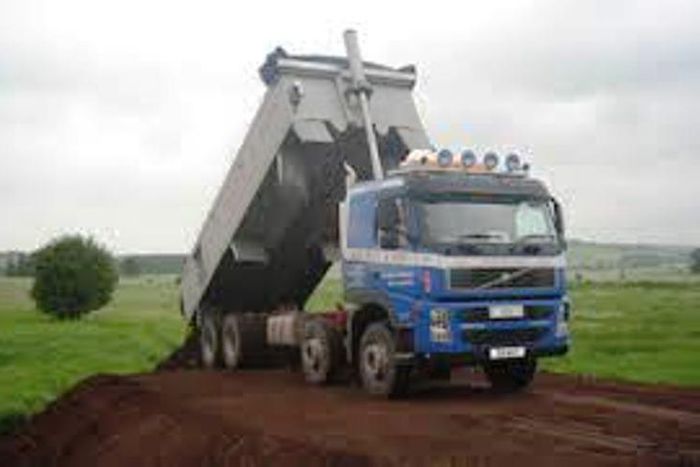 A sand truck dislodging its content