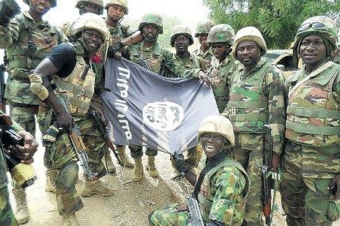 Nigerians soldiers destroy Boko Haram flag.