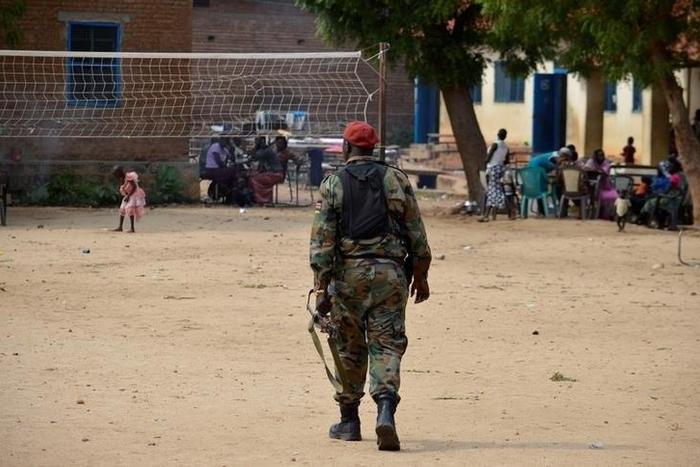 A soldier from the Sudan People's Liberation Movement (SPLM) walks within families displaced in recent fighting camping at the Anglican church compound in Juba, South Sudan, July 12, 2016.