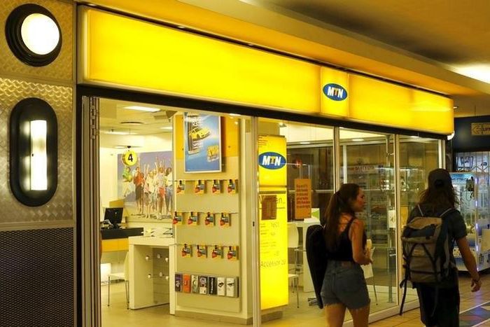 People walk past an outlet of South Africa's MTN Group in downtown Cape Town, November 10, 2015.  REUTERS/Mike Hutchings