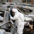 A French police officer inspects burned vehicles outside the Splendid Hotel in Ouagadougou, Burkina Faso, file.
