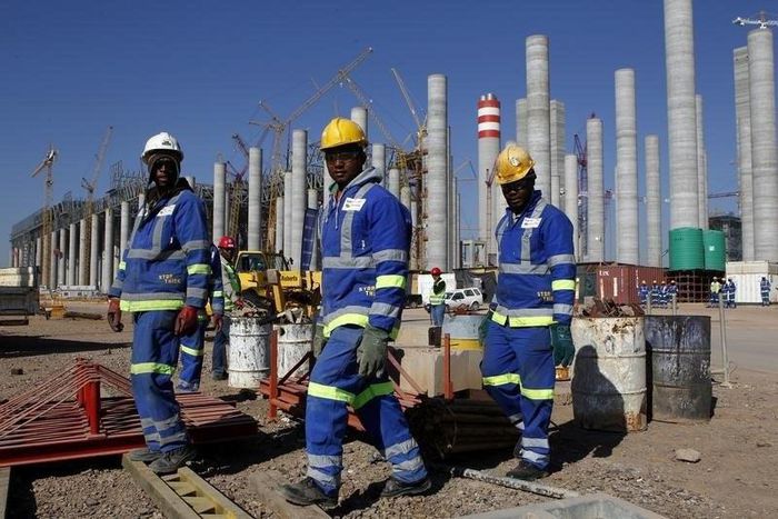 Workers are seen in front the construction site of Eskom's Medupi power station, a new dry-cooled coal fired power station, in Limpopo province, June 8, 2012.