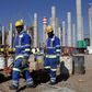 Workers are seen in front the construction site of Eskom's Medupi power station, a new dry-cooled coal fired power station, in Limpopo province, June 8, 2012.