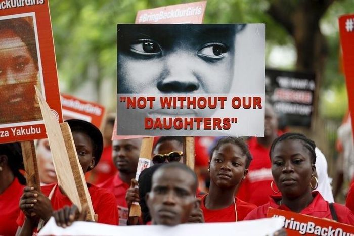 Bring Back Our Girls (BBOG) campaigners hold banners as they walk during a protest procession marking the 500th day since the abduction of girls in Chibok, along a road in Lagos August 27, 2015. REUTERS/Akintunde Akinleye