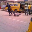 A policeman drags a civilian while some pedestrians kept their distance.