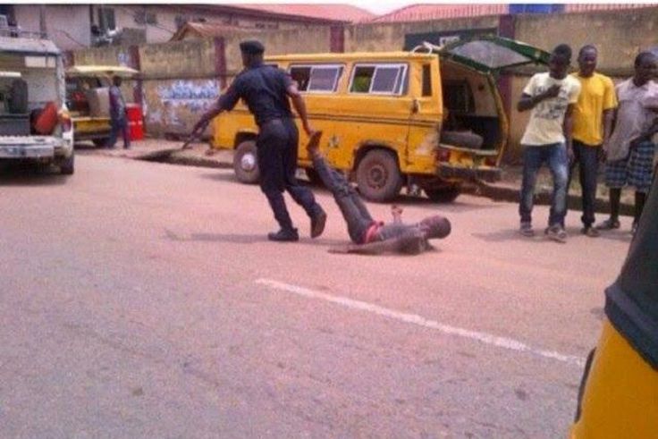 A policeman drags a civilian while some pedestrians kept their distance.