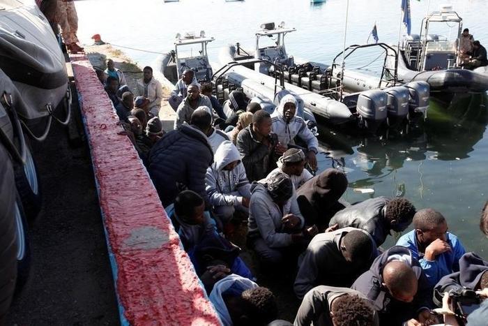 Migrants sit in a port, after being rescued at sea by Libyan coast guard, in Tripoli, Libya April 11, 2016.