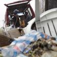 People walk past a pile of garbage along a street during rainfall, in Luanda, Angola, in this picture taken February 10, 2016.
