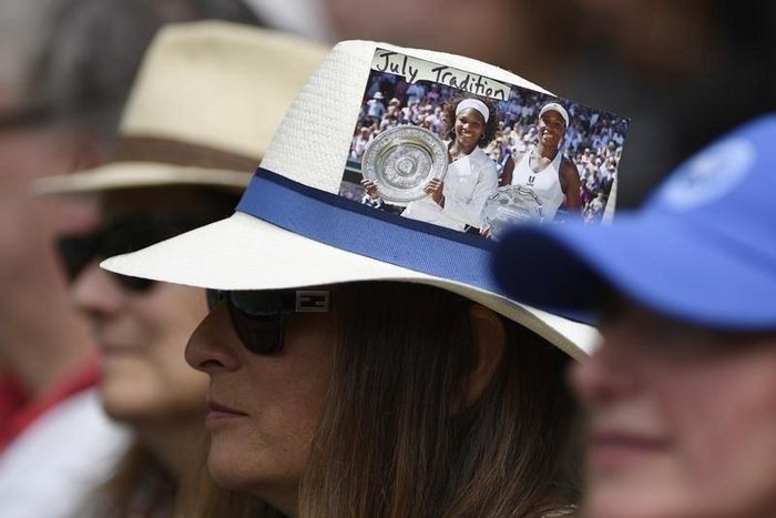 Britain Tennis - Wimbledon - All England Lawn Tennis & Croquet Club, Wimbledon, England - 3/7/16 A spectator on centre court with a picture of USA's Venus and Serena Williams attached to her hat before the start of play