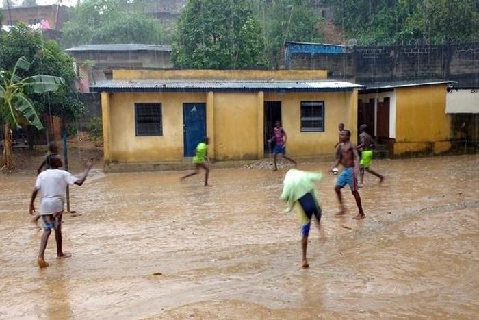 Youths play soccer in the rain at the Ndako ya Biso (Our House) refugee centre for street children in the Democratic Republic of Congo's capital Kinshasa, February 5, 2016. Picture taken February 5, 2016. REUTERS/Aaron Ross