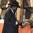 South Sudan's President Salva Kiir (L) and South Sudan's rebel commander Riek Machar exchange documents after signing a ceasefire agreement during the Inter Governmental Authority on Development (IGAD) Summit on the case of South Sudan in Ethiopia's ca...