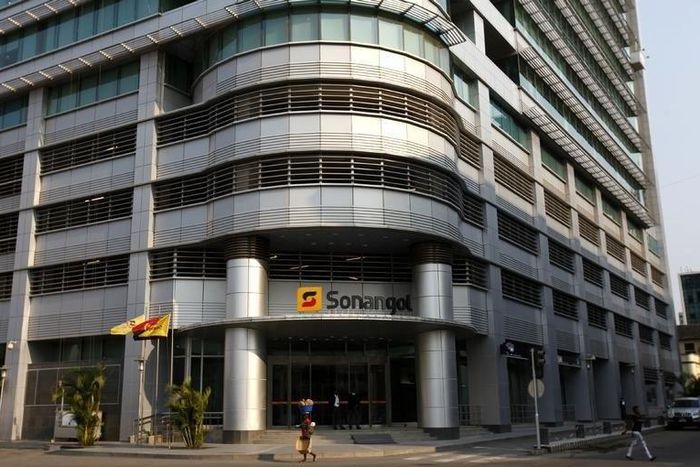 A woman walks past the head office of Angolan state oil company Sonangol in the capital Luanda, August 26, 2012.