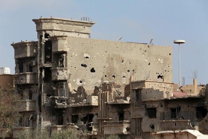 Buildings damaged during clashes between military forces loyal to Libya's eastern government and the Shura Council of Libyan Revolutionaries, an alliance of former anti-Gaddafi rebels who have joined forces with the Islamist group Ansar al-Sharia, are ...