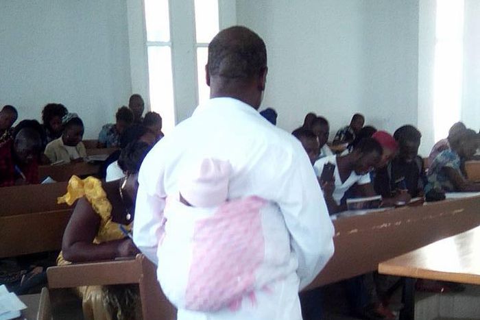 Professor helps woman to take care of her crying child during exam